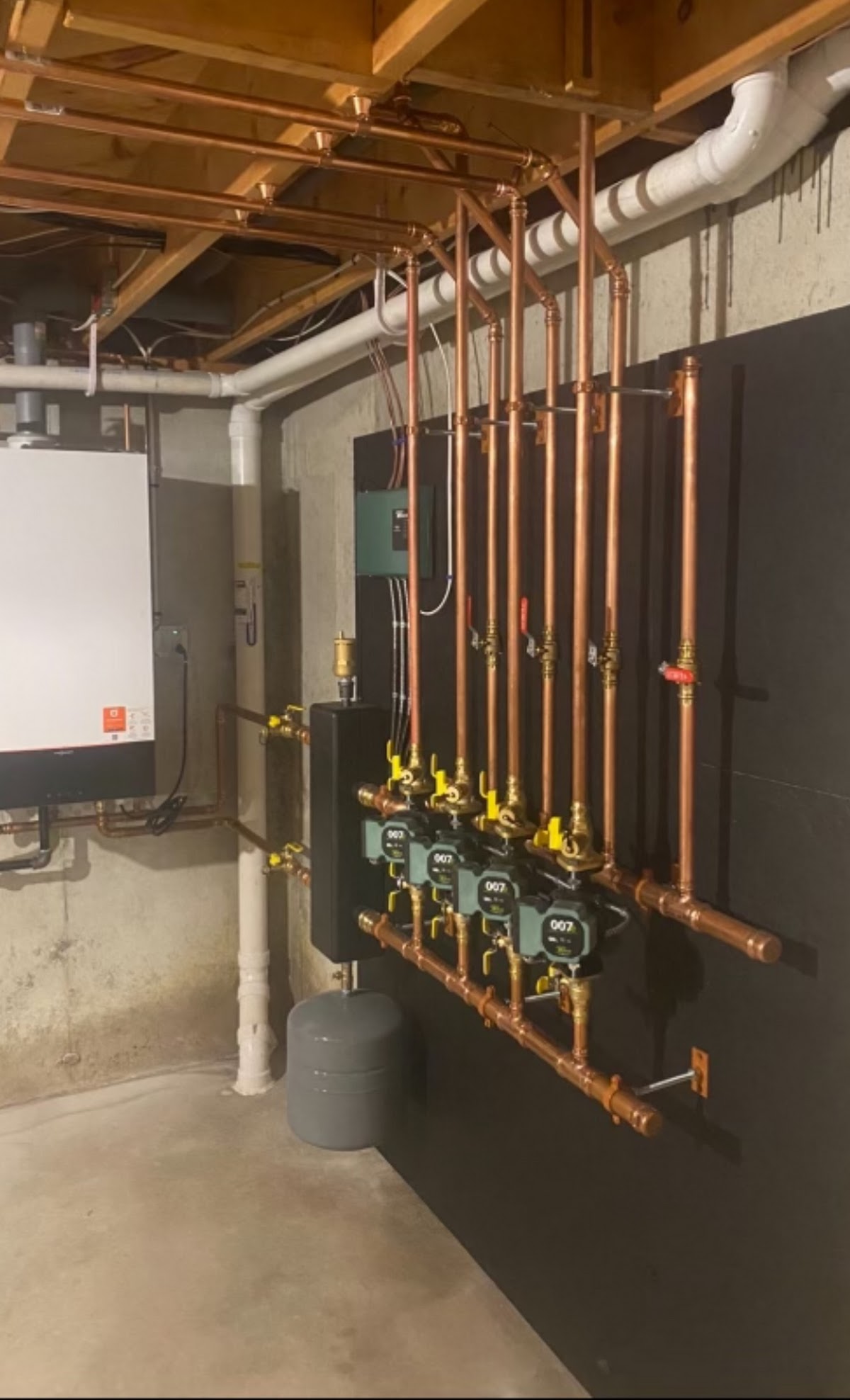Heating manifold and circulator pumps installed on a basement wall